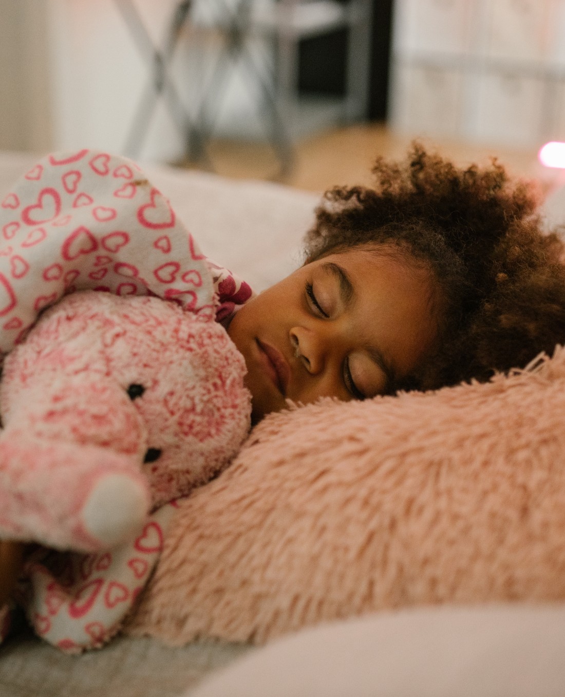 Sleeping kids cuddling a soft toy elephant